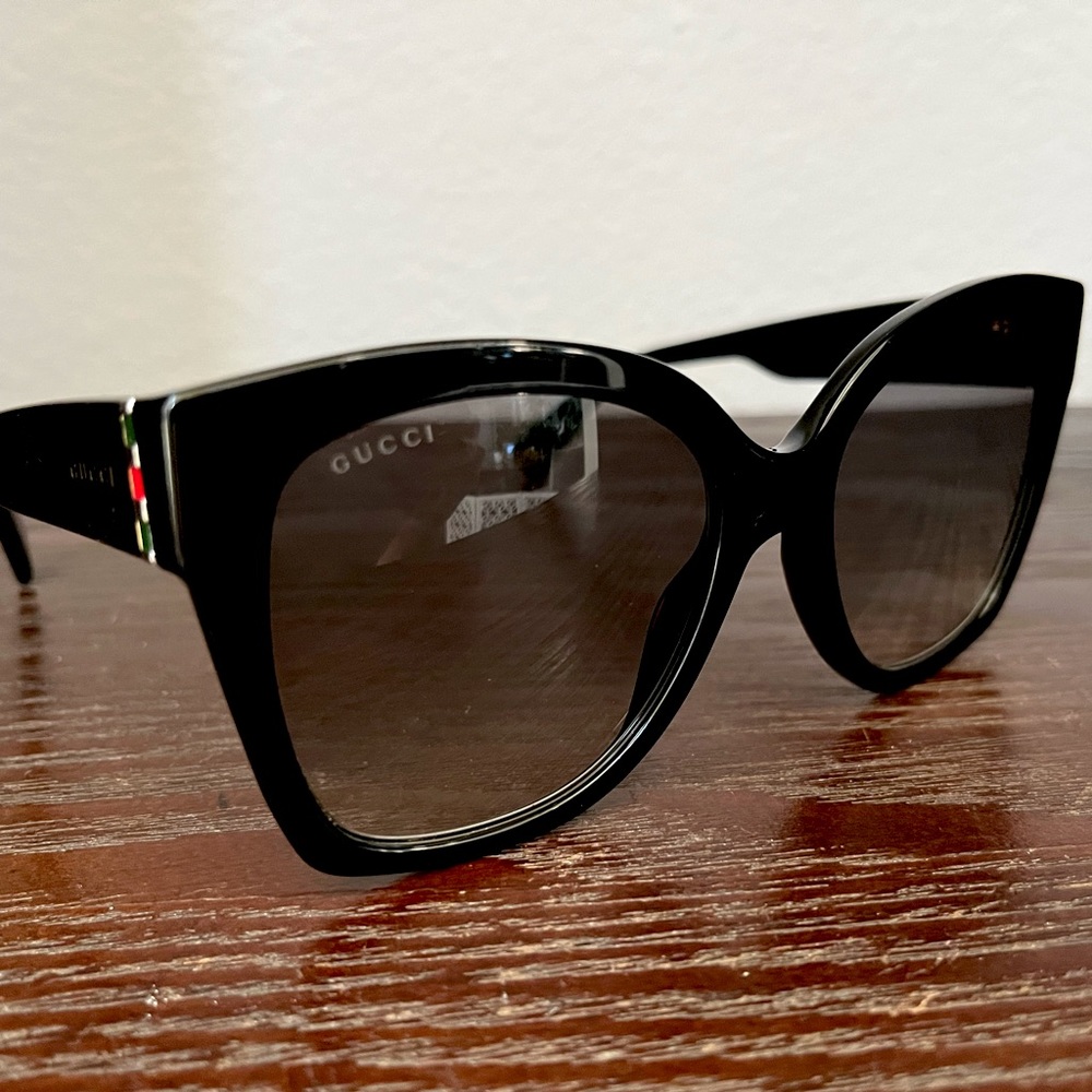 Authentic GUCCI glam sunglasses with black frame and grey gradient lens.